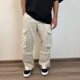 Pantalón jean color beige, de corte holgado y estilo cargo, con múltiples bolsillos laterales.