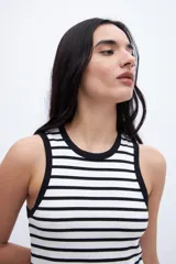 Musculosa corta a rayas horizontales blancas y negras con cuello y sisas ribeteadas en negro.