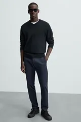 Pantalón chino color beige, corte skinny fit, confeccionado en tejido con mezcla de algodón y elasticidad. Cuenta con bolsillos frontales y traseros. Cierre frontal con cremallera y botón.