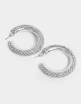 Aros tipo argolla plateados, cubiertos de strass blancos.