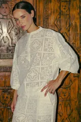 Blusa blanca con diseño calado, cuello mao y mangas 3/4 abullonadas.