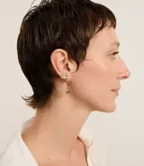 Set de tres pares de aros dorados. Un par de aros tipo argolla con dije de caracola, un par de aros tipo argolla lisa y un par de aros con forma de cangrejo.