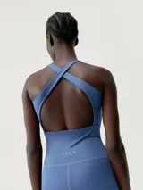 Mono largo de color azul, ajustado al cuerpo, con escote en V y tirantes anchos tipo halter. Presenta costuras visibles que definen la cintura y el busto.