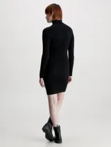 Vestido corto negro de punto acanalado, con cuello alto y mangas largas. Presenta logo de Calvin Klein bordado en el pecho.