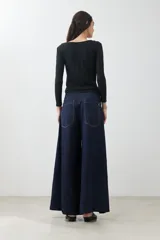Pantalón de jean wide leg color azul oscuro con cintura alta y cinturón de cadena plateada.