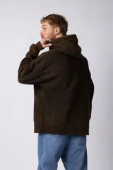 Buzo canguro marrón con capucha, confeccionado en frisa gruesa de algodón con recortes y calce oversize.