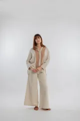 Camisa color beige con solapas y cierre con botones.