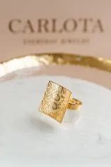 Anillo cuadrado en acero quirúrgico con baño de oro de 18k y textura labrada. Diseño liviano y cómodo, hipoalergénico.