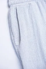 Pantalón celeste a rayas verticales blancas, confeccionado en tejido de algodón. Con cintura elastizada y cordón de algodón para regular el calce.