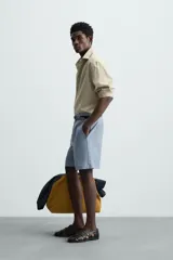 Bermuda de hombre color celeste claro, de corte regular fit, con textura arrugada y bolsillos frontales y traseros de plastrón.