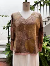 Remera de manga larga con escote en V, confeccionada en jersey de algodón peinado. Tiene detalle de morley en bajo mangas y tajos a los lados. Presenta estampa botánica.