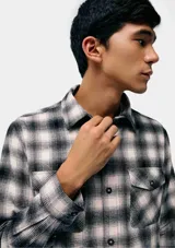 Camisa a cuadros de manga larga con dos bolsillos frontales con botón.