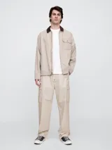 Pantalón cargo color beige, corte holgado, con bolsillos laterales con solapa y ajuste con cordón en la cintura.