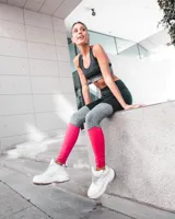 Calza deportiva larga con diseño color block en negro, gris y fucsia.