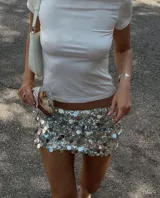 Minifalda color crema cubierta de lentejuelas.