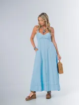 Vestido largo celeste en denim liviano con spandex, de corte amplio y espalda cruzada con drapeado elastizado.