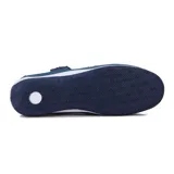 Zapato tipo guillermina color azul con calado en la capellada, ajuste con velcro y suela blanca.
