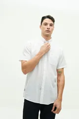 Camisa de manga corta confeccionada en lino y algodón color blanco, con fit regular y logo bordado. Modelo de la colección SS 26.