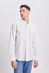 Camisa blanca de manga larga con cuello mao y cierre frontal con botones.