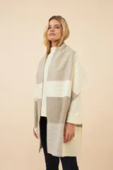 Chal unisex de lana fina sin teñir, realizado con retazos de telas diseñadas por Don Baez. Presenta una grifa de cuero aplicada.