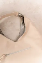 Bolso hobo reversible color azul marino, con textura símil cuero y correa bandolera extraíble.