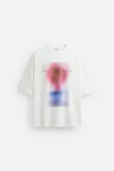 Camiseta blanca de corte relaxed fit, cuello redondo y manga corta. Estampado combinado a contraste en el delantero con imagen borrosa de flor y texto en azul.