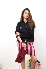 Chaqueta marrón de algodón con botones metálicos, cuello clásico, bolsillos frontales y apliques de tachas y botones formando una flor en la espalda.