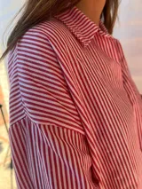 Camisa a rayas verticales rojas y blancas, de corte clásico y mangas largas.