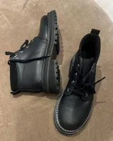 Borcego marrón de cuero con cordones, caña baja y suela track.