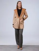 Chaqueta color beige de suede, marca Joan Vass. Cuello solapa, delantera con bolsillos. Cintura con pasadores y lazo de ajuste.