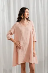 Vestido corto de lino color rosado, corte ancho y mangas 3/4, con escote en V.