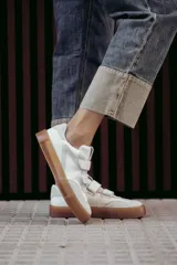 Zapatilla urbana con diseño moderno, mezcla de materiales y cierres de velcro.