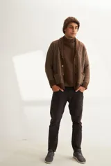 Cardigan tejido color marrón con cuello smoking, cierre con botones y bolsillos delanteros.