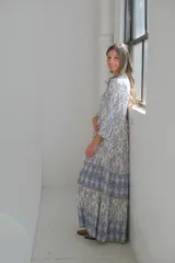 Vestido largo celeste y blanco con estampado geométrico, escote en V y mangas 3/4.