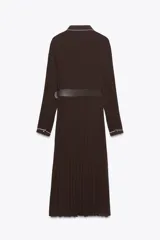 Vestido midi marrón chocolate plisado, con cuello solapa, manga larga y cinturón. Presenta cierre frontal con botones y vivos blancos a contraste en cuello, mangas y botonera. Incluye forro interior.