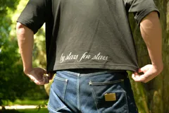 Chomba negra de corte cuadrado con cuello polo y mangas cortas. Presenta un escudo estampado en el pecho con diseño de fútbol retro y la palabra 'boxed' estampada en el frente.