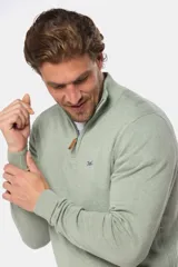 Sweater de punto fino color beige, con cuello alto y medio cierre frontal con cremallera.