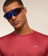 Remera deportiva blanca de poliéster, con cuello redondo, mangas cortas y recortes laterales.
