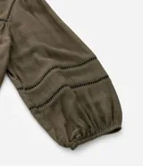Blusa verde militar de viscosa con escote cuadrado y mangas 3/4 abullonadas con elástico en los puños. Presenta inserciones en el escote y en las mangas.