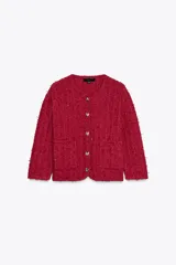 Chaqueta roja de tweed con cuello redondo, manga francesa, bolsillos delanteros y cierre frontal con botones dorados.