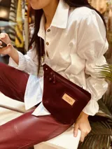 Riñonera de cuero color borgoña con correa ajustable.