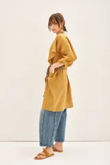 Saco color mostaza confeccionado en lino, de corte amplio y mangas largas. Incluye lazo estampado animal print.