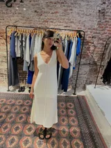 Vestido midi tejido color crema, con escote en V y calado en la parte inferior.