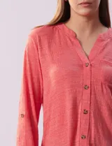 Blusa celeste texturada marca Ninety, con cuello a la base, escote en V y abertura central con botones. Delantera con bolsillo y mangas tres cuartos regulables con presilla y botón.