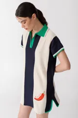 Vestido corto tejido en jersey liviano de algodón y acrílico, con diseño tipo polo y fit holgado. Presenta rayas verticales en color marrón y crudo, bordado XL de un ají y terminaciones en color amarillo.