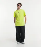Remera color amarillo flúor de corte recto, con cuello redondo y manga corta. Presenta un bordado de una rosa negra en el lado izquierdo del pecho.