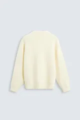 Jersey color crema de punto con textura, cuello redondo, manga larga y corte relaxed fit.