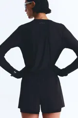 Short de correr negro de doble capa, con cintura elástica y cordón ajustable. Cuenta con una abertura lateral y un short interior con bolsillo en una pierna.