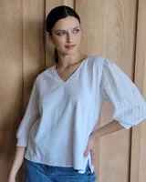 Blusa blanca de mangas 3/4 abullonadas con escote en V.