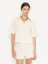 Remera color crema con textura de toalla con diseño floral, cuello camisero y mangas cortas.